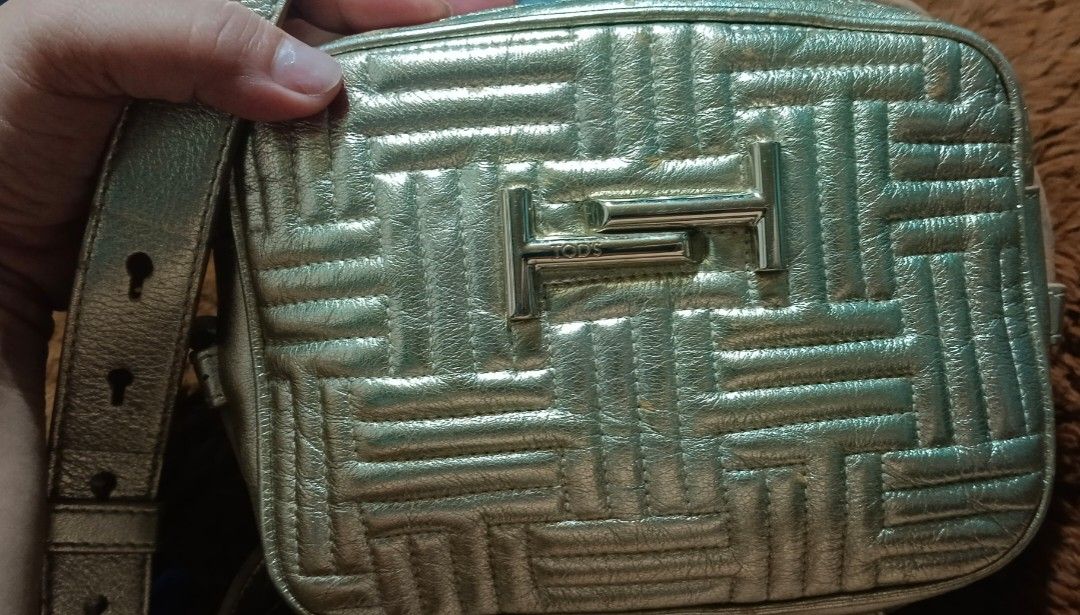 TOD'S Gold Quilted Leather Camera Bag (Category: Luxury Bags & Wallets) located in Legazpi City. Submitted by georgepineda791 (Listing ID 1443520984, Image 1). Description: TOD'S Gold Metallic Leather 3-way Bag - can be worn as a sling bag, body bag, or waist bag - Gold-tone leather exterior - Iconic T Timeless logo hardware - Elegant quilted pattern all over - Genuine leather, Made in Italy - Secure zipper closure - Adjustable strap for comforta