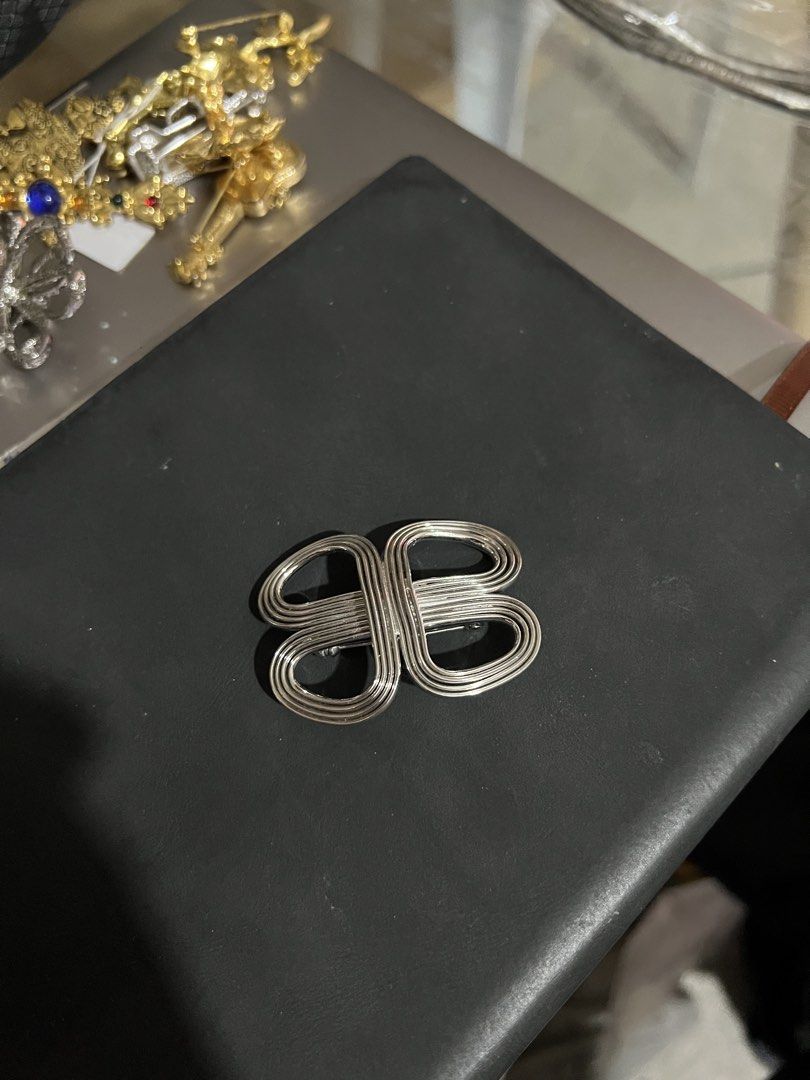 Vintage Silver Tone Interlocking Loop Brooch (Category: Brooches) located in Cagayan de Oro. Submitted by forevercurious (Listing ID 1443690160, Image 1). Description: - Unique silver tone brooch - Features an interlocking loop design - Approximately 2 inches wide - Adds a statement to jackets, scarves, or bags - Lightweight and easy to attach 📍 Poblacion, Makati.