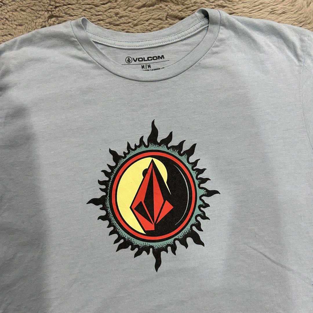 Volcom T-Shirt M/M Blue Graphic Tee (Category: Tshirts & Polo Shirts ) located in General Santos City (Dadiangas). Submitted by bosz_thirftgsc (Listing ID 1443575208, Image 2). Description: - Light blue Volcom t-shirt - Features iconic Volcom stone logo within a sun graphic - Size: Medium (M) - Material: 50% Cotton, 50% Polyester - Ideal for casual wear -18x26 -No Issue.