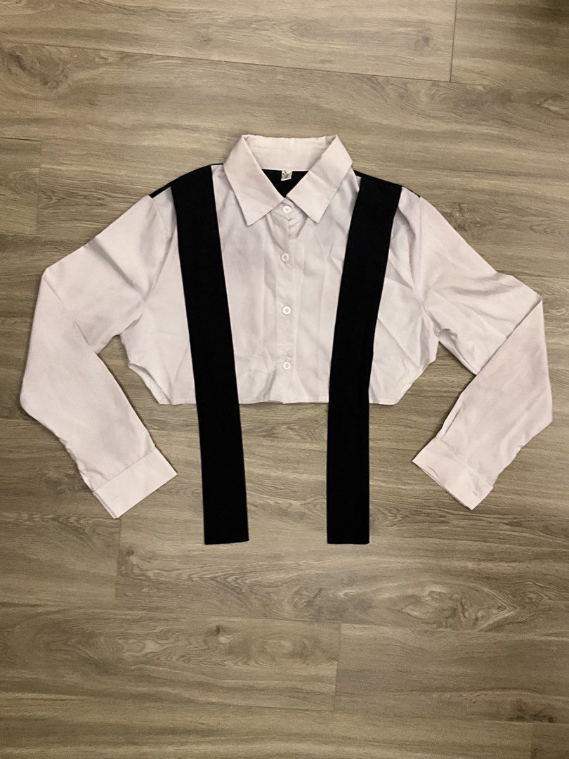 White Cropped Shirt with Black Tie (Category: Shirts) located in Las Pinas. Submitted by getl22 (Listing ID 1443512604, Image 1). Description: - White long-sleeved cropped shirt - Features black straps across the front - Button-up closure - Unique and versatile design - Great for layering or wearing solo.