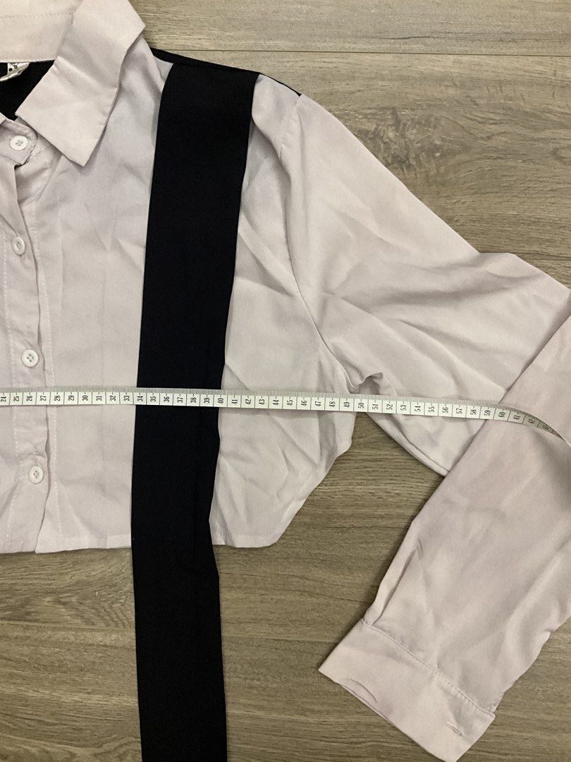 White Cropped Shirt with Black Tie (Category: Shirts) located in Las Pinas. Submitted by getl22 (Listing ID 1443512604, Image 3). Description: - White long-sleeved cropped shirt - Features black straps across the front - Button-up closure - Unique and versatile design - Great for layering or wearing solo.