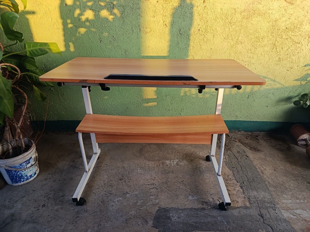 Adjustable Laptop Table with Wheels and Shelf (Category: Tables & Sets) located in Quezon City. Submitted by truephoenix.16cee3 (Listing ID 1443810107, Image 1). Description: - Adjustable height for comfortable use - Built-in shelf for extra storage - Rolls on wheels for easy mobility - Tilting tabletop for optimal viewing angle - Ideal for working from home or studying - Simple and functional design Manual measurements : Length: 80cm Width : 40c