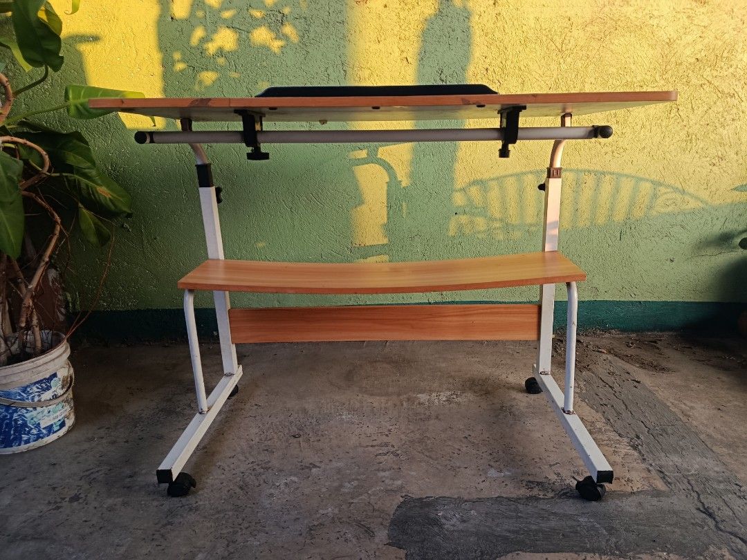 Adjustable Laptop Table with Wheels and Shelf (Category: Tables & Sets) located in Quezon City. Submitted by truephoenix.16cee3 (Listing ID 1443810107, Image 2). Description: - Adjustable height for comfortable use - Built-in shelf for extra storage - Rolls on wheels for easy mobility - Tilting tabletop for optimal viewing angle - Ideal for working from home or studying - Simple and functional design Manual measurements : Length: 80cm Width : 40c