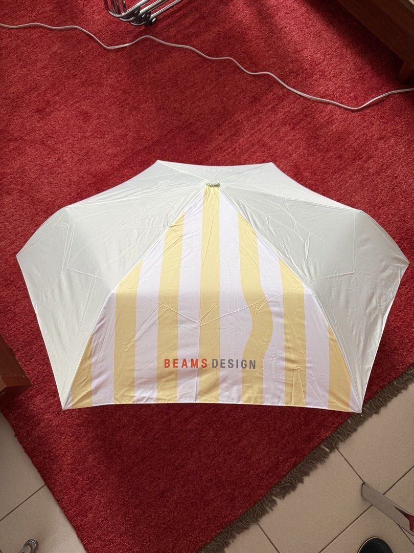 BEAMS DESIGN Striped Folding Umbrella Yellow White (Category: Umbrellas) located in Manila. Submitted by jcbagio20 (Listing ID 1443771494, Image 2). Description: 10 PIECES AVAILABLE!!! - Cute folding umbrella from BEAMS DESIGN - Features a stylish yellow and white stripe pattern - Compact and portable, ideal for on-the-go - Brand new, still in original packaging with tags attached - Perfect size to keep in your bag for unexpected rain.