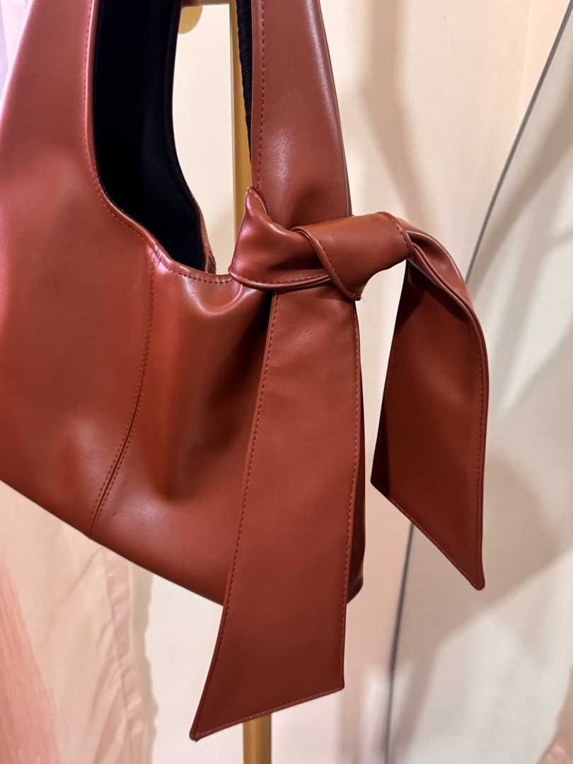 Bowie Shoulder Bag in Tan brown (Category: Shoulder Bags) located in Pasig City. Submitted by cattleyass (Listing ID 1443750682, Image 3). Description: Bought in Indonesia Detachable bow Geniune Leather Material Can fit Ipad 11in No discoloration No issues H13x W8.5in.