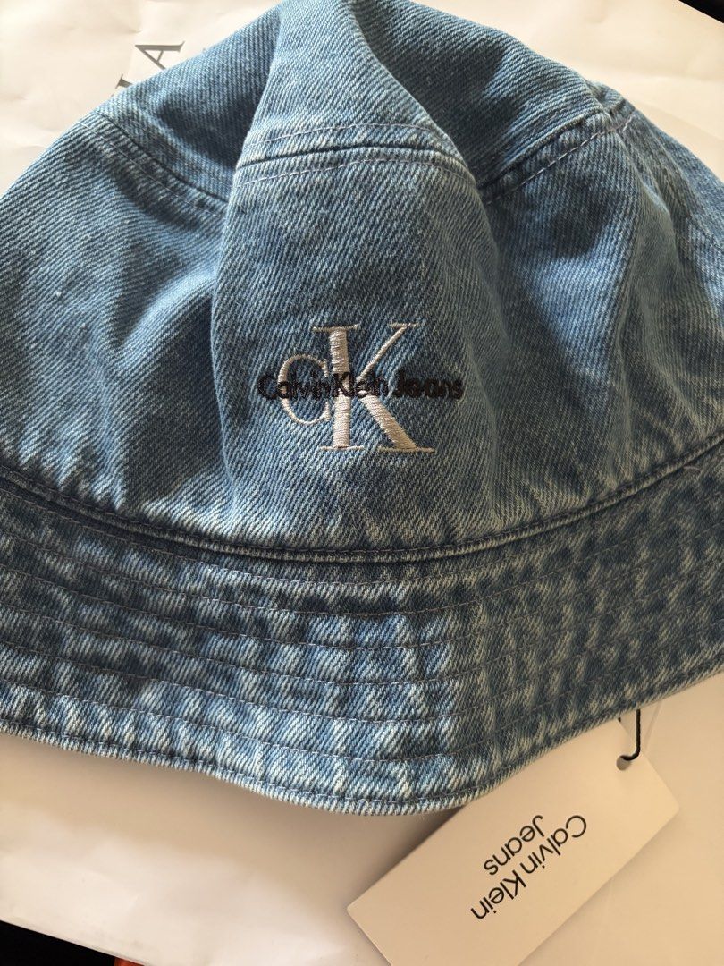 Calvin Klein Jeans Denim Bucket Hat (Category: Hats & Beanies) located in Quezon City. Submitted by rv1995 (Listing ID 1443778722, Image 1). Description: - Classic blue denim bucket hat from Calvin Klein Jeans - Features iconic CK logo embroidered on the front - Size: M - Brand new with original tag still attached - Ideal for sunny days and casual wear Featuring an unmistakable, iconic silhouette, this Calvin Klein bucket hat brings effortless st