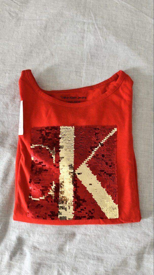 Calvin Klein Red Sequin Logo Long Sleeve Shirt (Category: Blouses) located in Manila. Submitted by mmsmims (Listing ID 1443746212, Image 3). Description: - Calvin Klein red long sleeve shirt-size 12-14 fits to xs-small women - Features a reversible sequin logo on the front (red and gold) - Elasticated hem for a comfortable fit - Brand new with original tags attached -.
