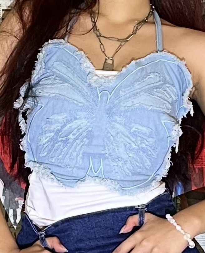Denim Butterfly Halter Crop Top (Category: Sleeveless) located in Manila. Submitted by declutter0_0 (Listing ID 1443781472, Image 2). Description: - Light wash denim crop top - Features a cute butterfly design - Frayed edges for a trendy look - Halter neck with tie closure - Versatile for pairing with jeans or skirts - Ideal for summer outfits.