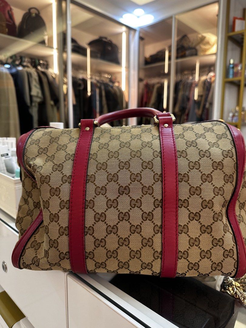 Gucci Monogram Canvas Red Leather Trim Boston Bag (Category: Luxury Bags & Wallets) located in Santo Domingo. Submitted by itznyxi3 (Listing ID 1443834185, Image 3). Description: - Authentic Gucci Boston Bag - Classic GG Monogram Canvas - Red Leather Trim and Handles - Zip Top Closure - Interior Zip Pocket and Slip Pockets - Detachable Shoulder Strap Included - Great for Everyday Essentials - Shows some signs of wear (inside and out), but has ple