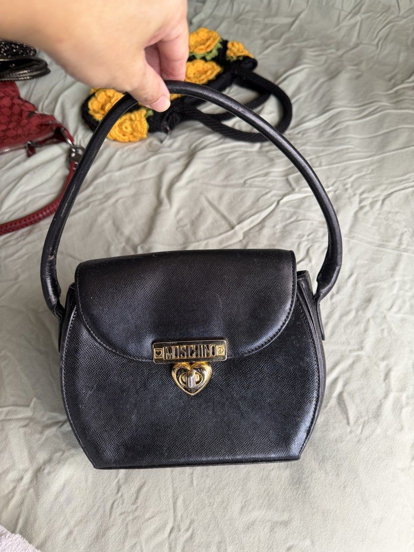 Moschino Black Heart Lock Shoulder Bag (Category: Luxury Bags & Wallets) located in Quezon City. Submitted by __lilyandpoppy (Listing ID 1443767603, Image 1). Description: - Vintage Moschino shoulder bag - Color: Black - Iconic gold heart lock closure - Moschino branding inside - Signs of wear on exterior and hardware (consistent with age) - Ideal for Moschino collectors - Classic piece.