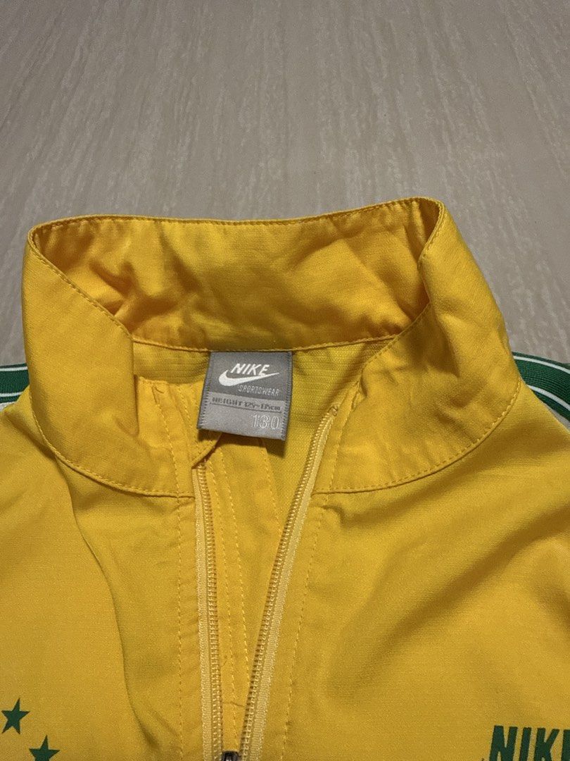 Nike SPRTSWR Track Jacket Yellow Green White (Category: Babies & Kids Fashion) located in Alfonso. Submitted by quickturtle_840b1e (Listing ID 1443821474, Image 3). Description: - Vibrant yellow Nike track jacket - Features green and white accent details - Iconic Nike logo on the chest - 'SPRTSWR' text with stars on the left chest - Full zip closure for easy wear - Perfect for athletic activities or everyday casual style PM me for queries 😊.