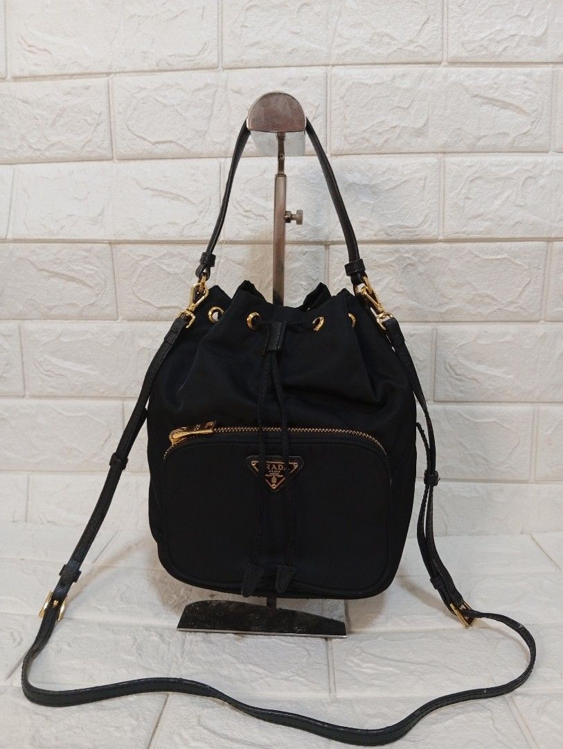 Prada Duet Re-Nylon Drawstring Bucket Bag (Category: Luxury Bags & Wallets) located in Las Pinas. Submitted by etoksi1234 (Listing ID 1443891537, Image 1). Description: Pre-loved Prada Duet Re-Nylon black bucket bag with gold hardware. Features adjustable strap, drawstring closure, and with RIRI front zip pocket. Made in Italy with white tag..