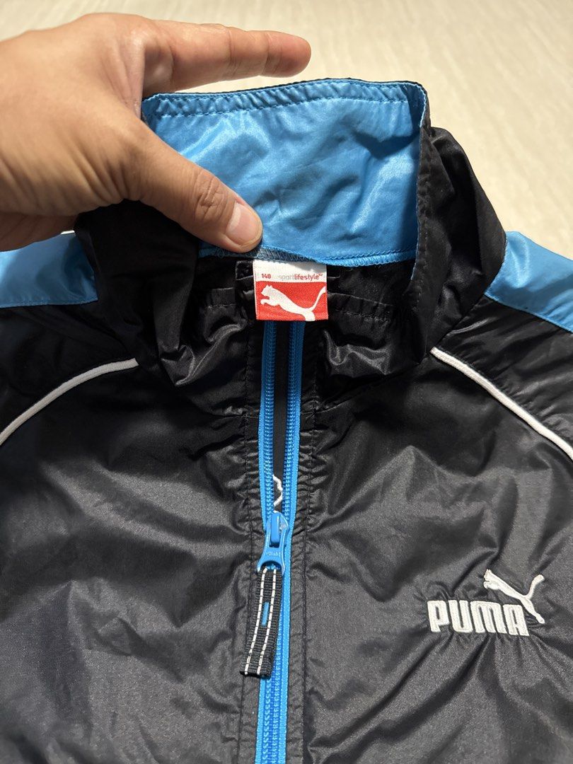 Puma Track Jacket Black Blue White (Category: Babies & Kids Fashion) located in Alfonso. Submitted by quickturtle_840b1e (Listing ID 1443824168, Image 2). Description: - Puma track jacket - Color: Black with blue and white accents - Features: Full zip closure, two side pockets - Design: Elasticated cuffs and hem - Versatile: Great for sports or casual wear PM me for queries 😊.