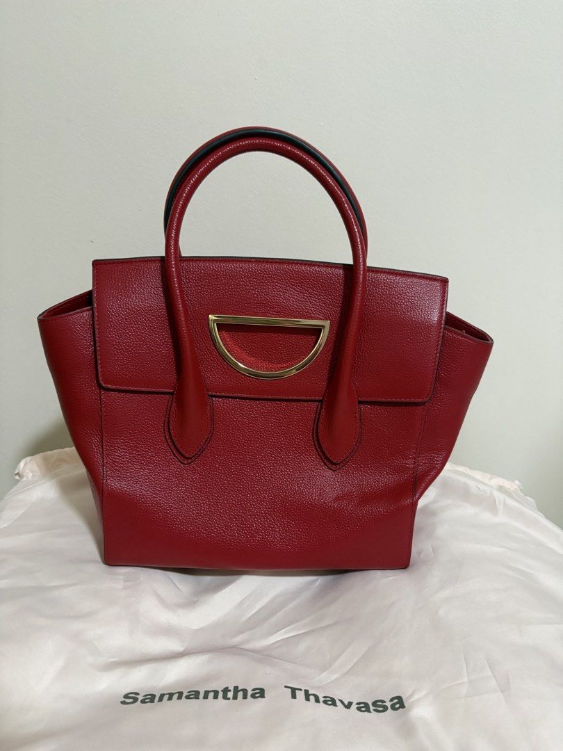 Samantha Thavasa Red Leather Top Handle Bag (Category: Luxury Bags & Wallets) located in Del Monte. Submitted by gentlehawk-37b0 (Listing ID 1443751340, Image 1). Description: - Authentic Samantha Thavasa red leather handbag - Textured leather finish - Elegant gold hardware detail on the front - Comfortable top handles for carrying - Spacious interior for all your essentials - Comes with original dust bag - Versatile: perfect for daily use or spe