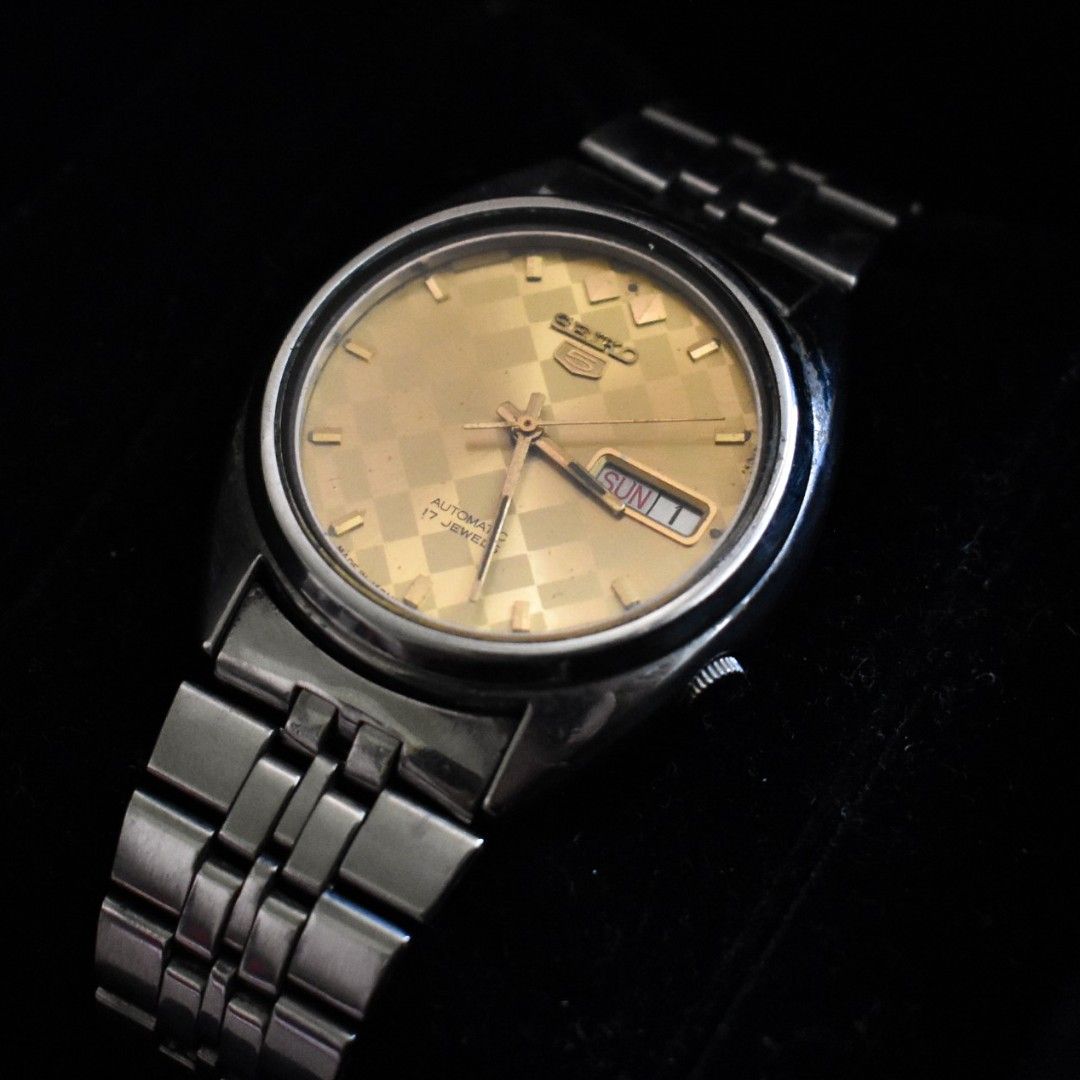 Seiko 5 Automatic Watch - Gold Dial (Category: Men's Watches) located in Makati City. Submitted by _damitnilawrence (Listing ID 1443795847, Image 1). Description: - Vintage Seiko 5 Automatic Watch - 37mm case - Serial 7009-3040 - Rpoduction 1981 or 1991 - Striking Gold Checkered Dial - Day and Date Complication - Stainless Steel Bracelet with Seiko Clasp - Water Resistant - Base Metal Bezel - Shows some signs of wear on case and bracelet - Runs w