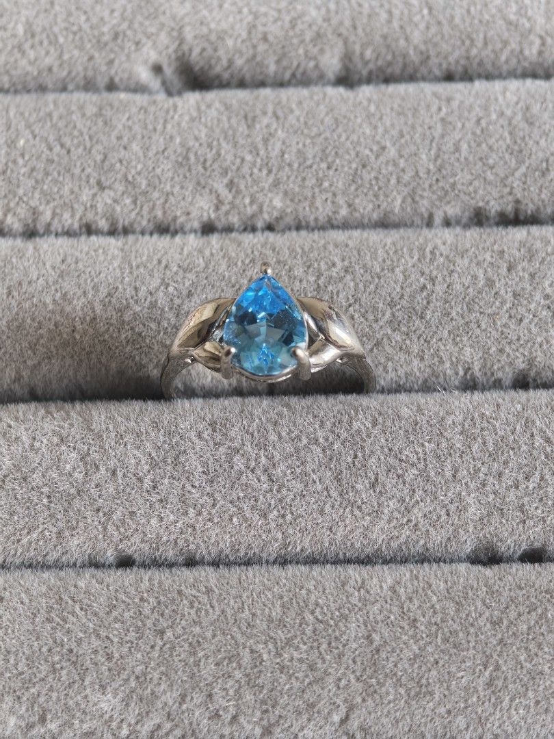 Sky Blue Topaz Ring in Silver Band (Category: Rings) located in Batangas. Submitted by decluttering_bliss (Listing ID 1443791799, Image 1). Description: - Stunning pear-cut sky blue topaz - Elegant silver-toned band - Intricate leaf-like design on the band sides - Versatile for everyday wear or special events - Eye-catching sparkle - Ideal as a thoughtful gift.