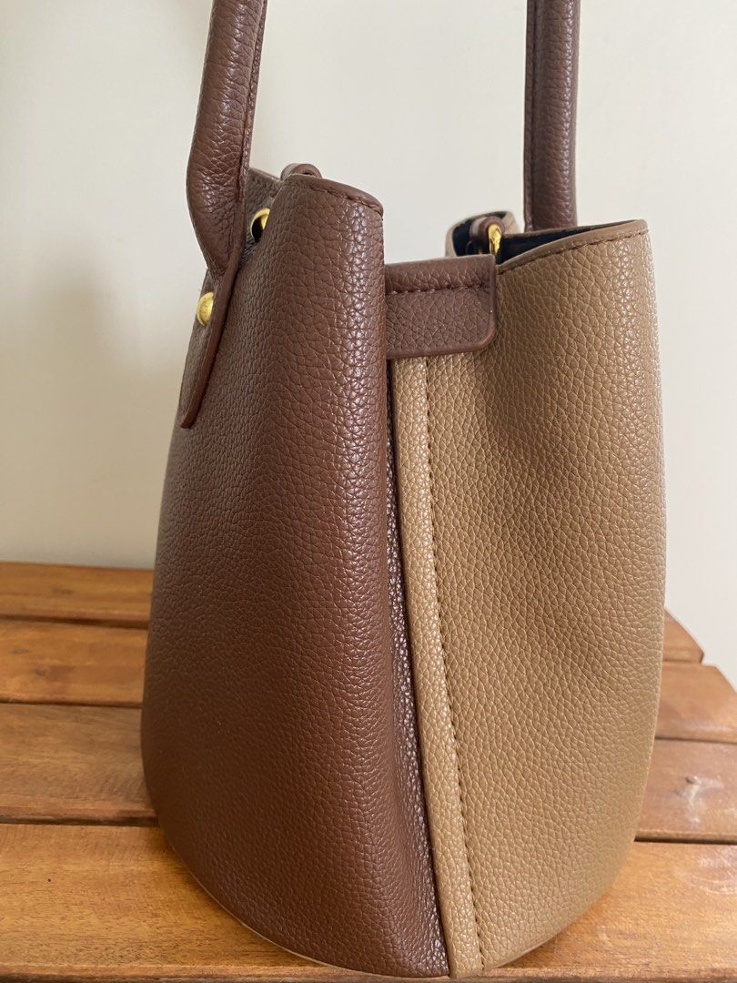 Two-tone brown bucket bag with top handle (Category: Cross-body Bags) located in Santa Rosa. Submitted by summerbrunch (Listing ID 1443712141, Image 3). Description: - Adorable two-tone brown bucket bag - Convenient top handle for easy carrying - Interior zipped pocket for secure storage - Magnetic snap closure for quick access - Chic gold hardware details - Ideal for your everyday adventures.