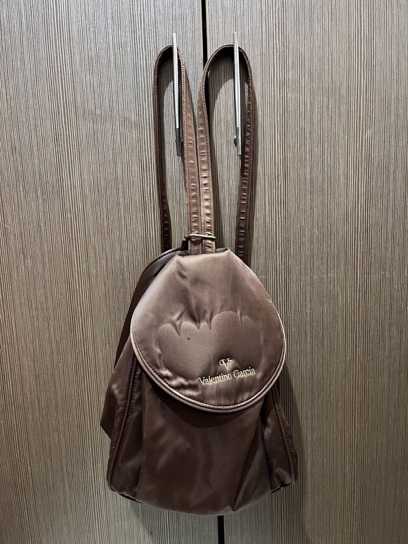 Valentino Garcia Brown Satin Backpack (Category: Backpacks) located in Pasig City. Submitted by olivealice (Listing ID 1443809822, Image 1). Description: - Brown satin backpack by Valentino Garcia - Features embroidered V logo and brand name on front flap - Adjustable straps for comfortable wear - Spacious interior, ideal for daily essentials - Chic and cute everyday bag Bought in Japan.