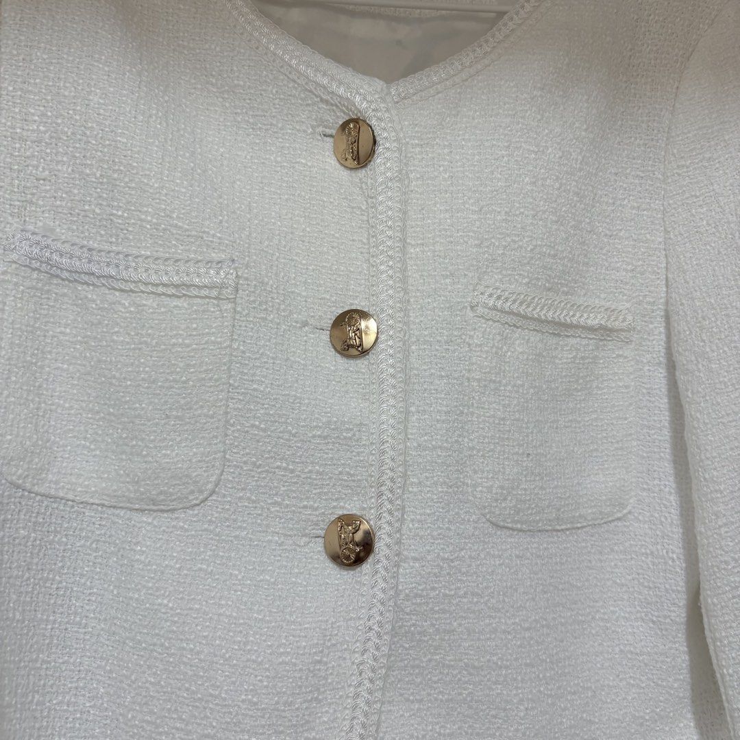 White Tweed Blazer Jacket with Gold Buttons (Category: Coats, Jackets and Outerwear) located in Manila. Submitted by cluttersbya (Listing ID 1443706931, Image 3). Description: - White tweed cropped jacket - Textured fabric - Collarless neckline - Two front pockets with button details - Gold button accents on front and cuffs - Chic and classic style - Perfect for dressing up or down.