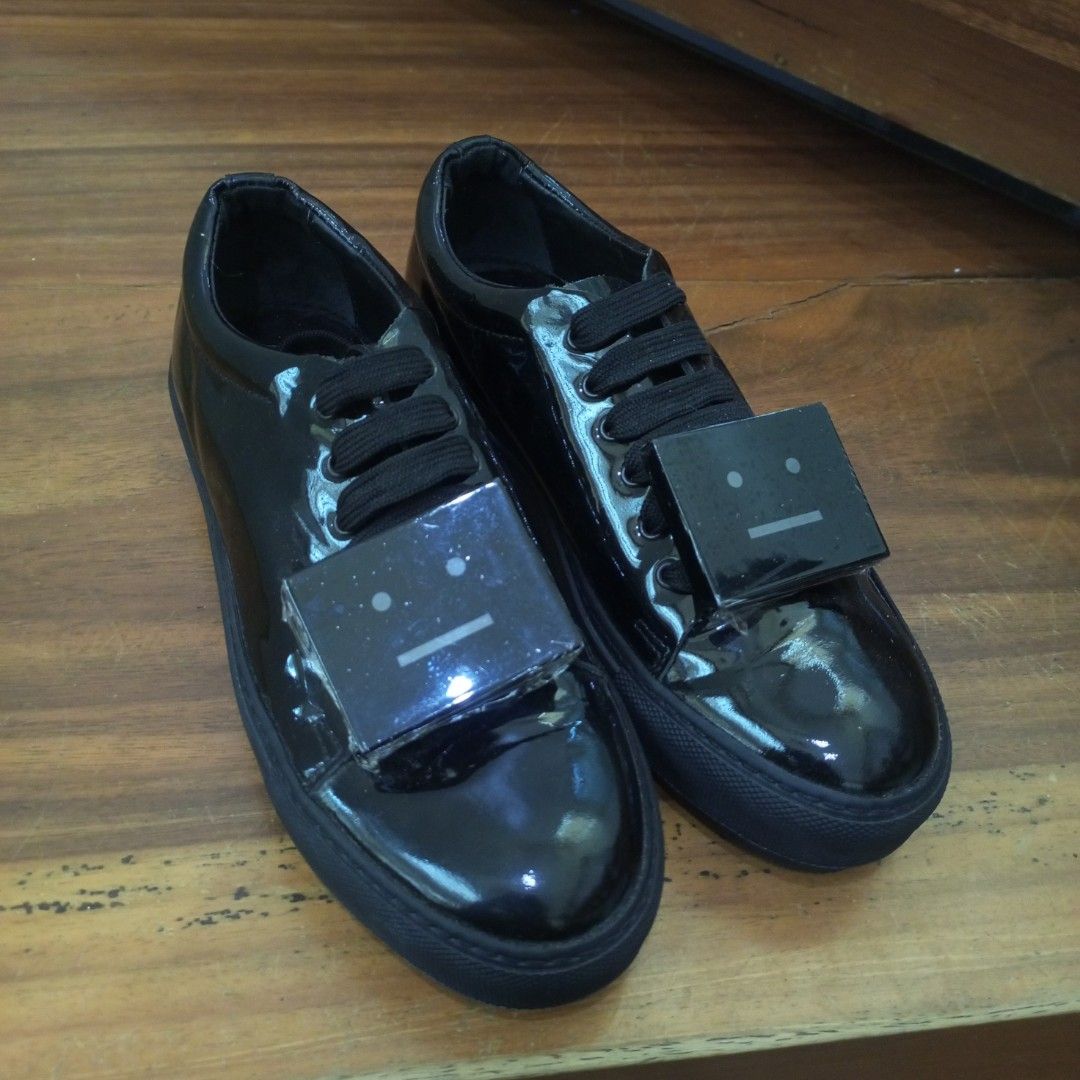 Acne Studios Black Patent Face Motif Sneakers (Category: Sneakers & Footwear) located in Calamba. Submitted by closet_from_the_past (Listing ID 1443938467, Image 2). Description: - Brand: Acne Studios -Size 6.6 - Material: Black patent leather - Feature: Signature face motif on front - Closure: Lace-up - Origin: Made in Italy - Style: Super shiny, eye-catching, statement piece.