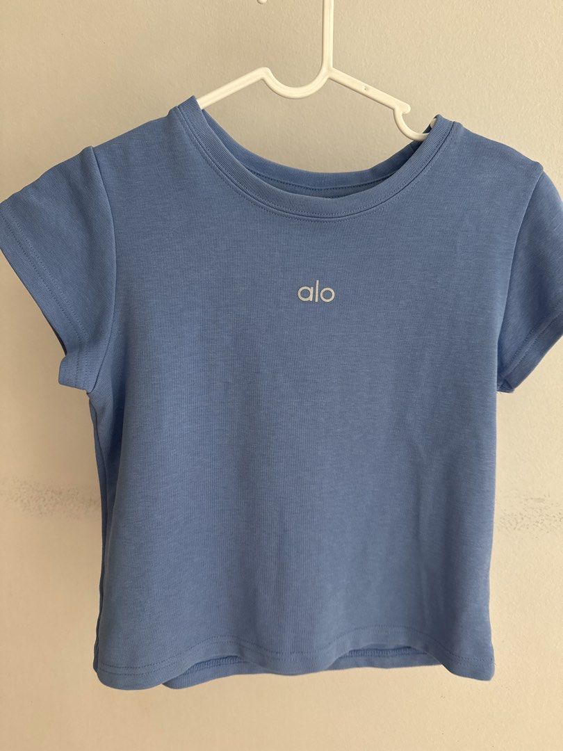 Alo Scuba Blue Ribbed Cropped T-Shirt Size L (Category: Shirts) located in Singapore. Submitted by greatworldand (Listing ID 1443925048, Image 1). Description: - Pretty blue Alo t-shirt - Ribbed material - Cropped style - Logo on front - Size L - Made in China - Care: Do not wash with like colors.