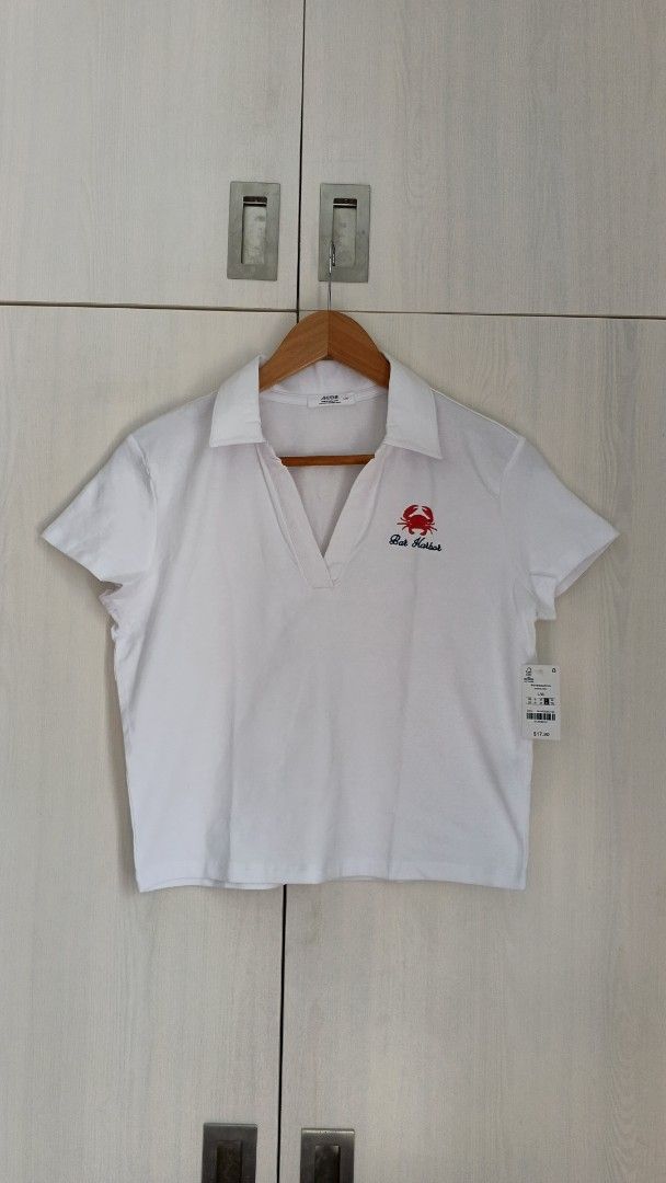 Ardene White Cropped Polo Shirt (Category: Blouses) located in Marikina City. Submitted by cheantone (Listing ID 1443972429, Image 1). Description: Bust | 19" Shoulder | 16" Length | 20".