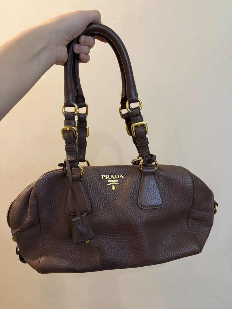 Authentic Prada Vitello Daino Brown Leather Bag (Category: Luxury Bags & Wallets) located in Quezon City. Submitted by purpleblush (Listing ID 1444033012, Image 2). Description: Prada Vitello Daino Bowling Bag in Brown Crafted from Prada’s signature Vitello Daino pebbled leather with gold-tone hardware. Features a timeless bowling bag silhouette, rolled leather handles, zip-top closure, and spacious interior. A classic and versatile Prada piece t