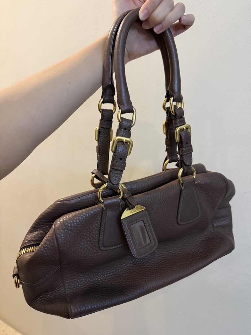 Authentic Prada Vitello Daino Brown Leather Bag (Category: Luxury Bags & Wallets) located in Quezon City. Submitted by purpleblush (Listing ID 1444033012, Image 3). Description: Prada Vitello Daino Bowling Bag in Brown Crafted from Prada’s signature Vitello Daino pebbled leather with gold-tone hardware. Features a timeless bowling bag silhouette, rolled leather handles, zip-top closure, and spacious interior. A classic and versatile Prada piece t