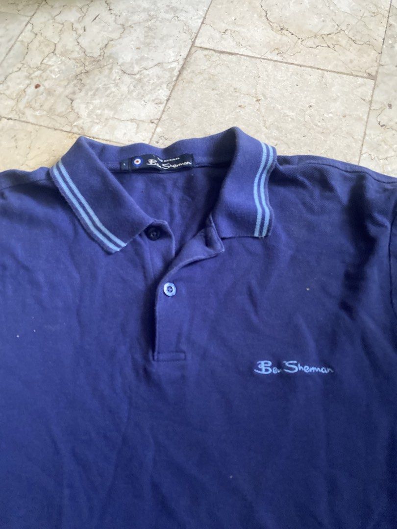 Ben Sherman Men's Navy Blue Polo Shirt (Category: Tshirts & Polo Shirts ) located in Paranaque City. Submitted by antoniomar45104 (Listing ID 1443935982, Image 2). Description: - Classic Ben Sherman polo shirt - Navy blue with light blue striped collar and cuffs - Two-button placket - Embroidered chest logo - Comfortable cotton material - Ideal for casual or smart-casual outfits.