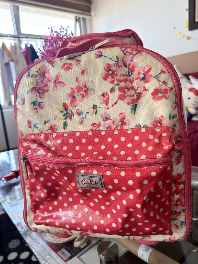 Cath Kidston Kids Floral Polka Dot Rolling Backpack (Category: Backpacks) located in Manila. Submitted by ameerafaye (Listing ID 1443922430, Image 1). Description: - Adorable Cath Kidston backpack for kids - Charming floral print on cream with pink polka dot pockets - Features a retractable handle and wheels for easy rolling - Spacious interior for school supplies or travel essentials - Zippers are in good working condition - Ideal for little adv