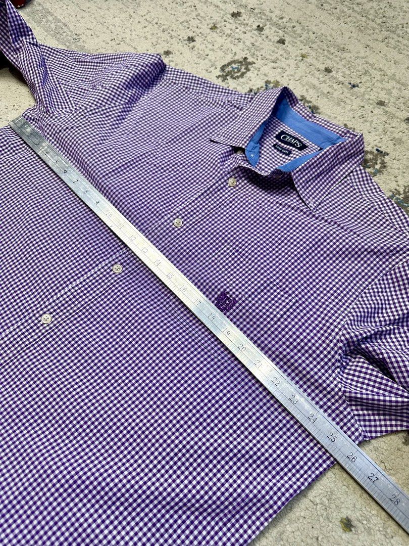Chaps Purple Gingham Long Sleeve Button Down Shirt Men's Size (Category: Tshirts & Polo Shirts ) located in Daet. Submitted by thrifthings2018 (Listing ID 1443988955, Image 3). Description: - Chaps button down shirt - Classic purple and white gingham pattern - Long sleeves with button cuffs - Easy care fabric for convenience - Subtle chest logo detail - Measurements: Width 26 inches, Length 32 inches - Versatile for casual or smart casual occasio