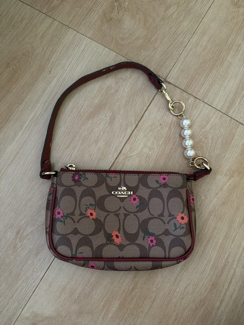 Coach Monogram Baguette Bag (Category: Luxury Bags & Wallets) located in Santa Rosa. Submitted by decluttering_. (Listing ID 1443922139, Image 1). Description: Rfs: decluttering MOP: Gcash MOD: Lalamove/Jnt - authentic coach - Features a cute floral pattern - Burgundy trim and interior - Includes card slots inside - Detachable pearl charm strap - Gold hardware - Ideal for carrying your essentials.