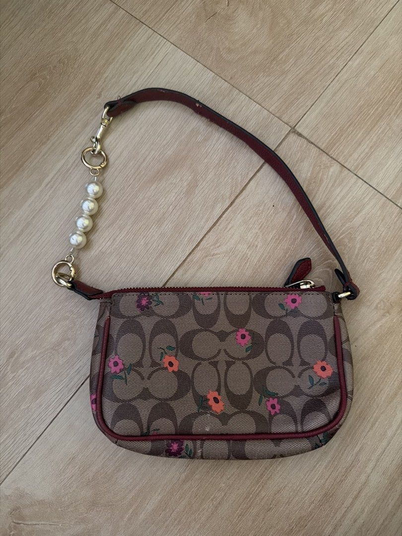 Coach Monogram Baguette Bag (Category: Luxury Bags & Wallets) located in Santa Rosa. Submitted by decluttering_. (Listing ID 1443922139, Image 2). Description: Rfs: decluttering MOP: Gcash MOD: Lalamove/Jnt - authentic coach - Features a cute floral pattern - Burgundy trim and interior - Includes card slots inside - Detachable pearl charm strap - Gold hardware - Ideal for carrying your essentials.