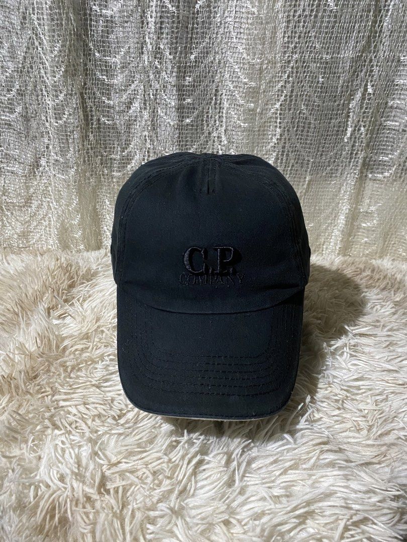 C.P. Company Black Cotton Baseball Cap (Category: Caps & Hats) located in Aurora. Submitted by sidethrift.deer (Listing ID 1444023671, Image 1). Description: - Brand: C.P. Company - Color: Black - Material: Cotton - Features: Adjustable strap at the back with C.P. Company logo - Sizing: One size fits all - Style: Great for everyday wear - Condition: Please check photos for details.