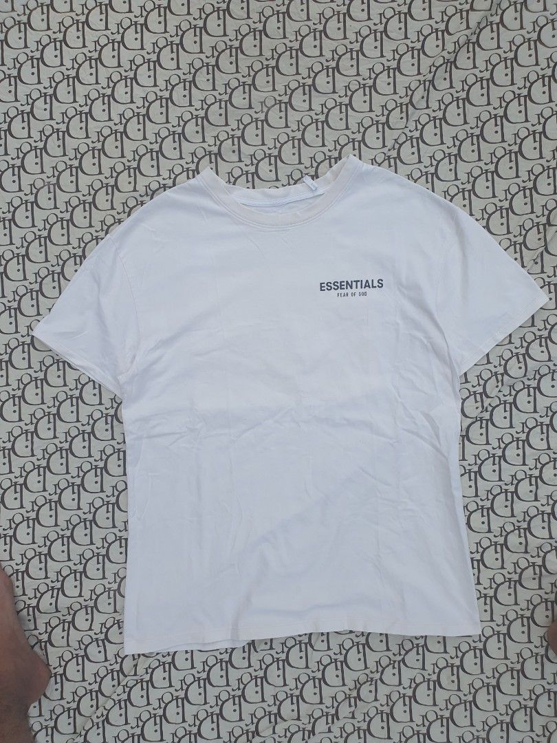 Fear of God Essentials White T-Shirt (Category: Tshirts & Polo Shirts ) located in San Fernando. Submitted by retro.district. (Listing ID 1444030687, Image 1). Description: - Brand: Fear of God Essentials - Color: White - Design: Features the iconic brand logo on the chest. - Back Detail: Includes a cool graphic print on the back. - Style: Comfortable and stylish, ideal for everyday casual wear. - Condition: Please check photos for detailed condi