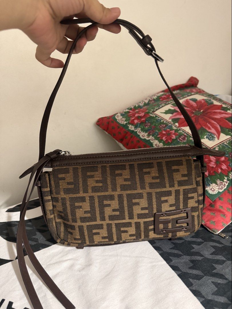 Fendi Zucca Canvas Baguette Bag (Category: Luxury Bags & Wallets) located in Del Monte. Submitted by shiminmishi (Listing ID 1441193747, Image 1). Description: - Fendi Zucca canvas baguette bag - Classic brown and black monogram print - Genuine leather trim and strap - Secure zipper closure - Compact size, perfect for essentials - Please note: Shows some signs of wear on the leather trim and strap NGA! with etiketa and code. no issue or flaws pre