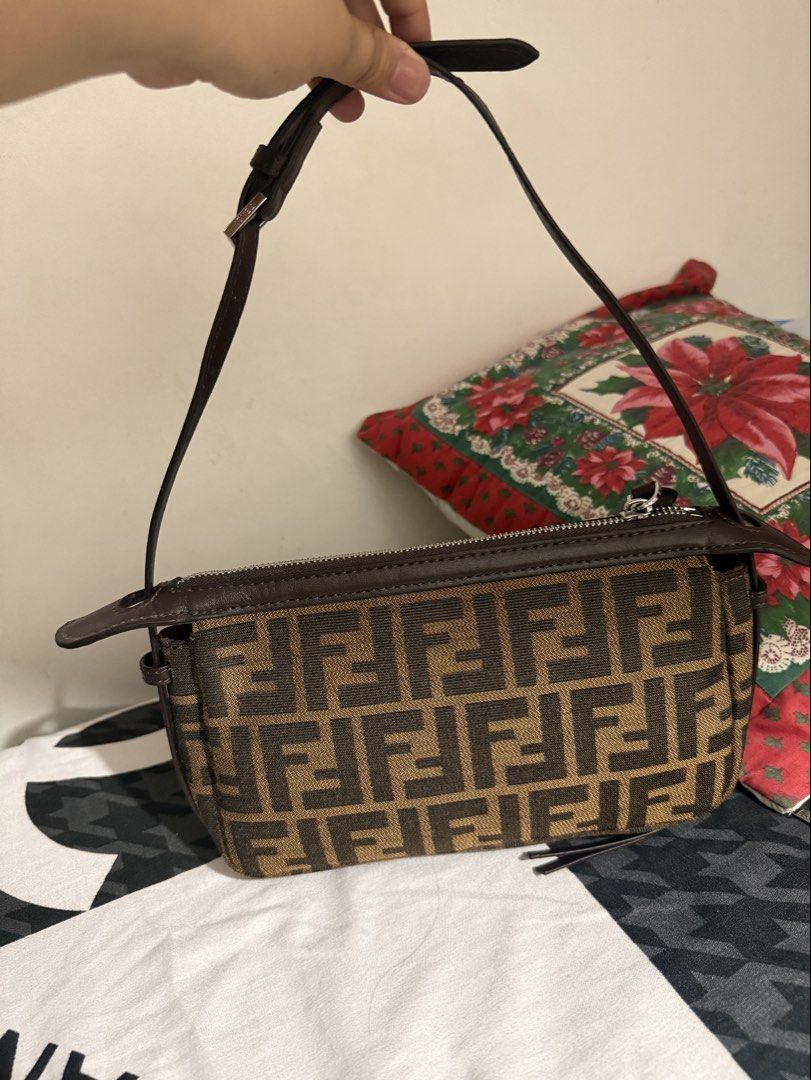 Fendi Zucca Canvas Baguette Bag (Category: Luxury Bags & Wallets) located in Del Monte. Submitted by shiminmishi (Listing ID 1441193747, Image 2). Description: - Fendi Zucca canvas baguette bag - Classic brown and black monogram print - Genuine leather trim and strap - Secure zipper closure - Compact size, perfect for essentials - Please note: Shows some signs of wear on the leather trim and strap NGA! with etiketa and code. no issue or flaws pre