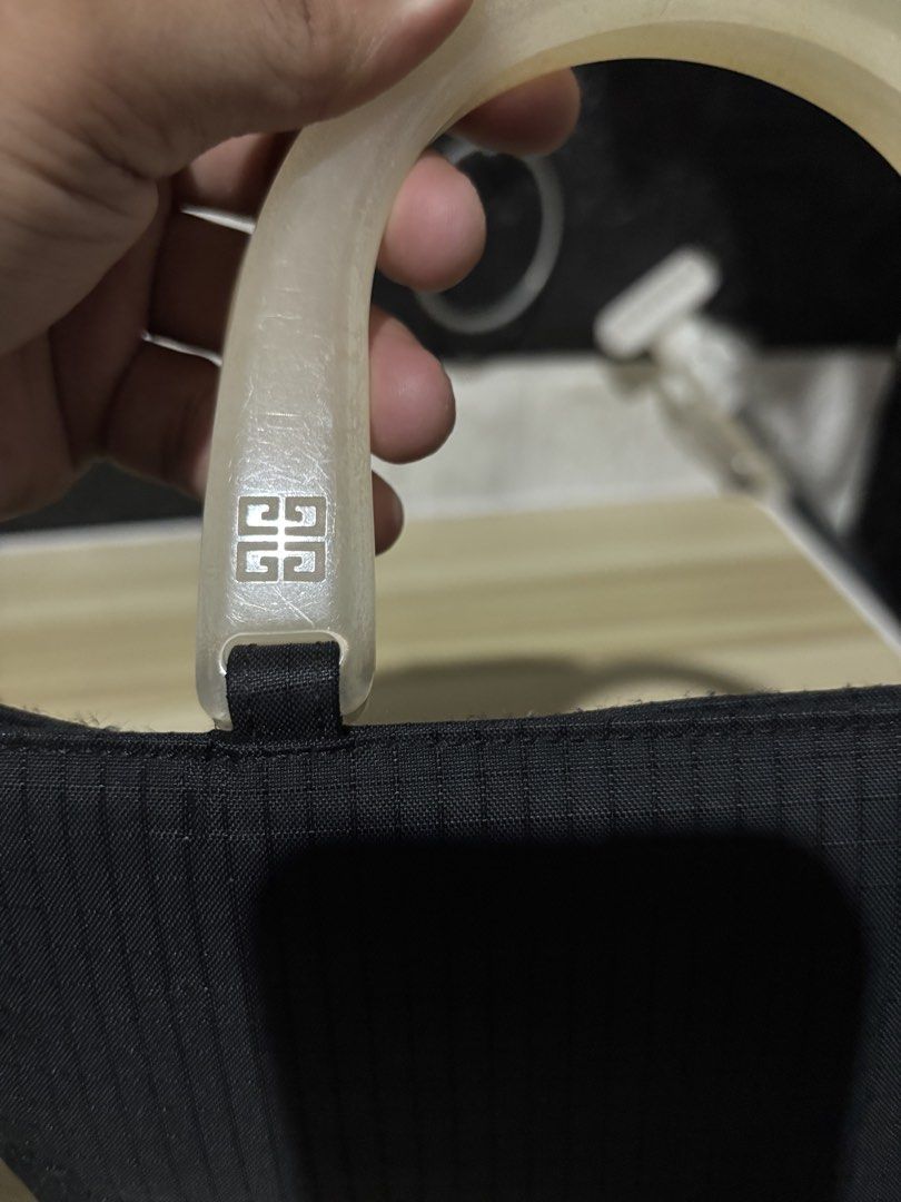 Givenchy Black Nylon Handbag with Translucent Handles (Category: Luxury Bags & Wallets) located in Lopez. Submitted by thrift.ni.roms22 (Listing ID 1444111029, Image 3). Description: - Stylish black nylon handbag - Features iconic Givenchy logo on translucent handles - Convenient zippered pocket on the front - Spotless and clean interior - Ideal for everyday wear and tear.