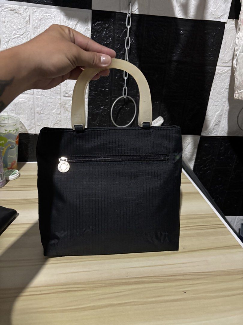 Givenchy Black Nylon Handbag with Translucent Handles (Category: Luxury Bags & Wallets) located in Lopez. Submitted by thrift.ni.roms22 (Listing ID 1444111029, Image 2). Description: - Stylish black nylon handbag - Features iconic Givenchy logo on translucent handles - Convenient zippered pocket on the front - Spotless and clean interior - Ideal for everyday wear and tear.