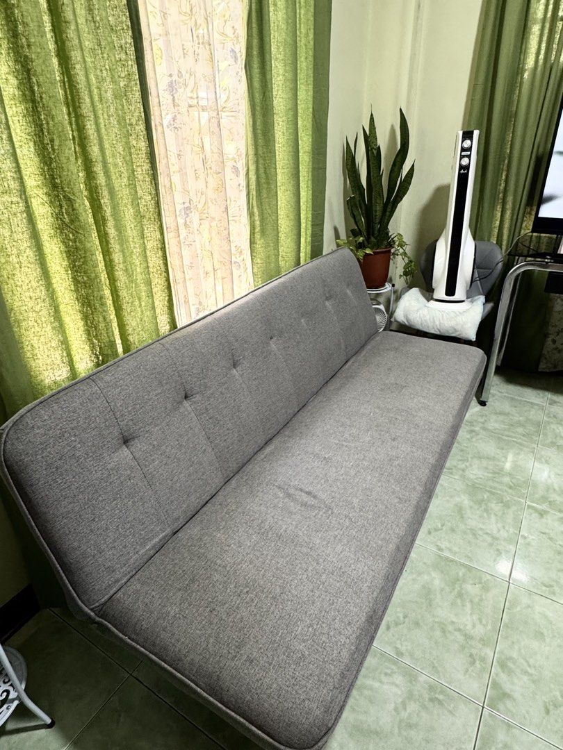 Grey Sofa Bed and Green Armchair Set (Category: Sofas) located in Lucena. Submitted by angelicadon (Listing ID 1443978356, Image 2). Description: - Grey sofa bed with pull-out function, perfect for guests. - Comfortable and spacious green armchair. - Both pieces are fabric upholstered. - Selling as a set. - Pick up only..