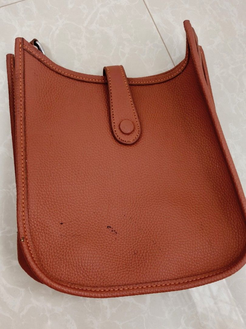 Hermes Constance Shoulder Bag (Category: Luxury Bags & Wallets) located in Balanga. Submitted by mattambok (Listing ID 1443975545, Image 2). Description: - Stylish orange leather shoulder bag - Features a classic H cutout design - Compact size, ideal for carrying essentials - Interior is clean and well-maintained - Comes with a detachable strap - Perfect for everyday wear and casual outings.