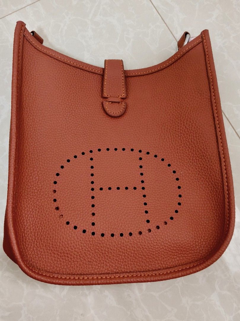 Hermes Constance Shoulder Bag (Category: Luxury Bags & Wallets) located in Balanga. Submitted by mattambok (Listing ID 1443975545, Image 1). Description: - Stylish orange leather shoulder bag - Features a classic H cutout design - Compact size, ideal for carrying essentials - Interior is clean and well-maintained - Comes with a detachable strap - Perfect for everyday wear and casual outings.