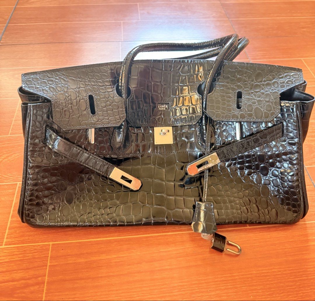 Hermes Paris Black Crocodile Embossed Handbag (Category: Luxury Bags & Wallets) located in Taguig. Submitted by ara0813 (Listing ID 1444046164, Image 1). Description: - Elegant black crocodile embossed handbag - Luxurious silver hardware details - Comfortable top handles - Secure clasp closure - Includes a lock and key for added security - Spacious interior with multiple compartments - Crafted in France - Dimensions: Approximately 14" wide, 10" t