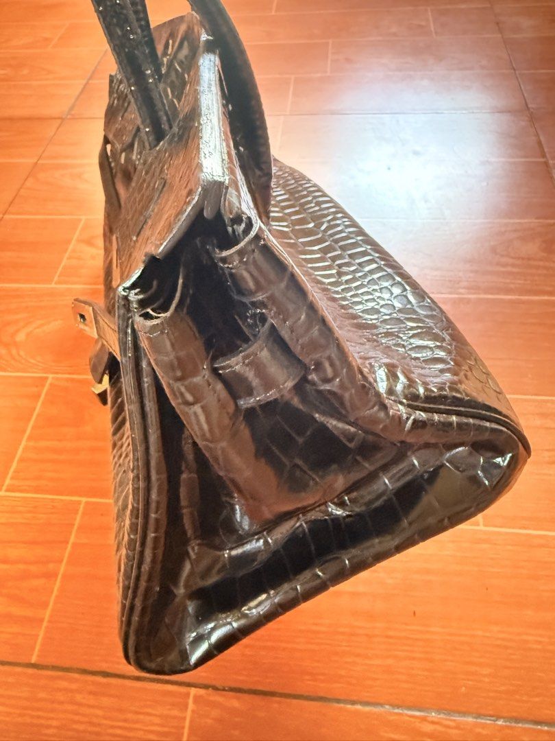 Hermes Paris Black Crocodile Embossed Handbag (Category: Luxury Bags & Wallets) located in Taguig. Submitted by ara0813 (Listing ID 1444046164, Image 3). Description: - Elegant black crocodile embossed handbag - Luxurious silver hardware details - Comfortable top handles - Secure clasp closure - Includes a lock and key for added security - Spacious interior with multiple compartments - Crafted in France - Dimensions: Approximately 14" wide, 10" t