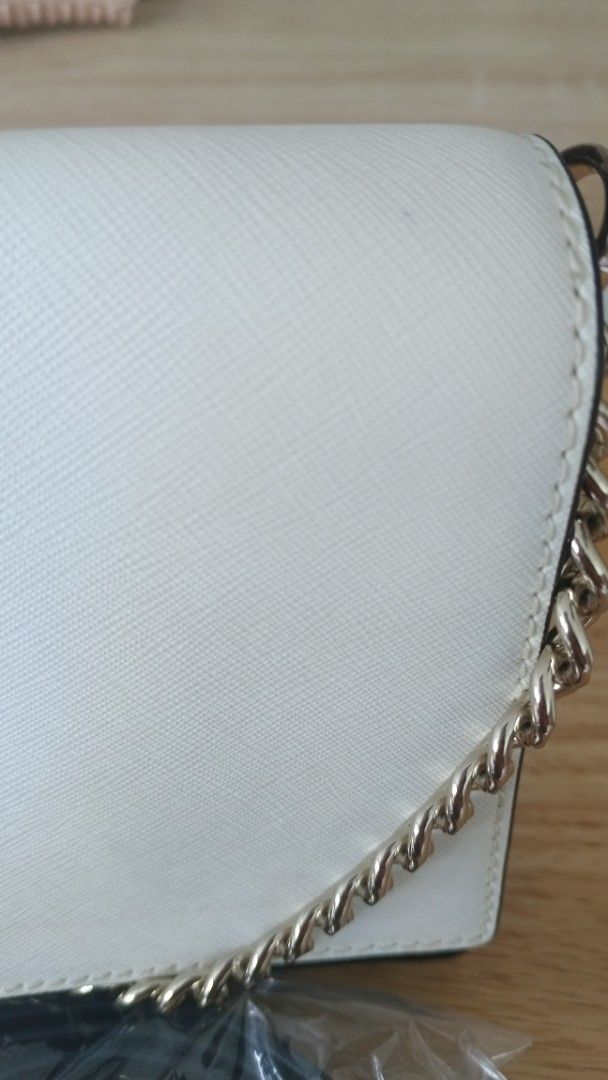 Kate Spade White and Black Chain Shoulder Bag (Category: Luxury Bags & Wallets) located in Candelaria. Submitted by elchas (Listing ID 1443962727, Image 2). Description: - Authentic Kate Spade bag in white and black. - Features a stylish gold chain strap. - Comes with an additional black strap, still in original packaging. - Elegant and clean design. - Versatile for both daytime and evening use..