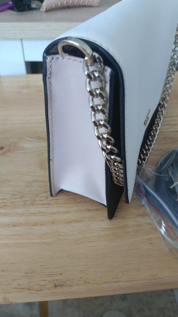 Kate Spade White and Black Chain Shoulder Bag (Category: Luxury Bags & Wallets) located in Candelaria. Submitted by elchas (Listing ID 1443962727, Image 3). Description: - Authentic Kate Spade bag in white and black. - Features a stylish gold chain strap. - Comes with an additional black strap, still in original packaging. - Elegant and clean design. - Versatile for both daytime and evening use..
