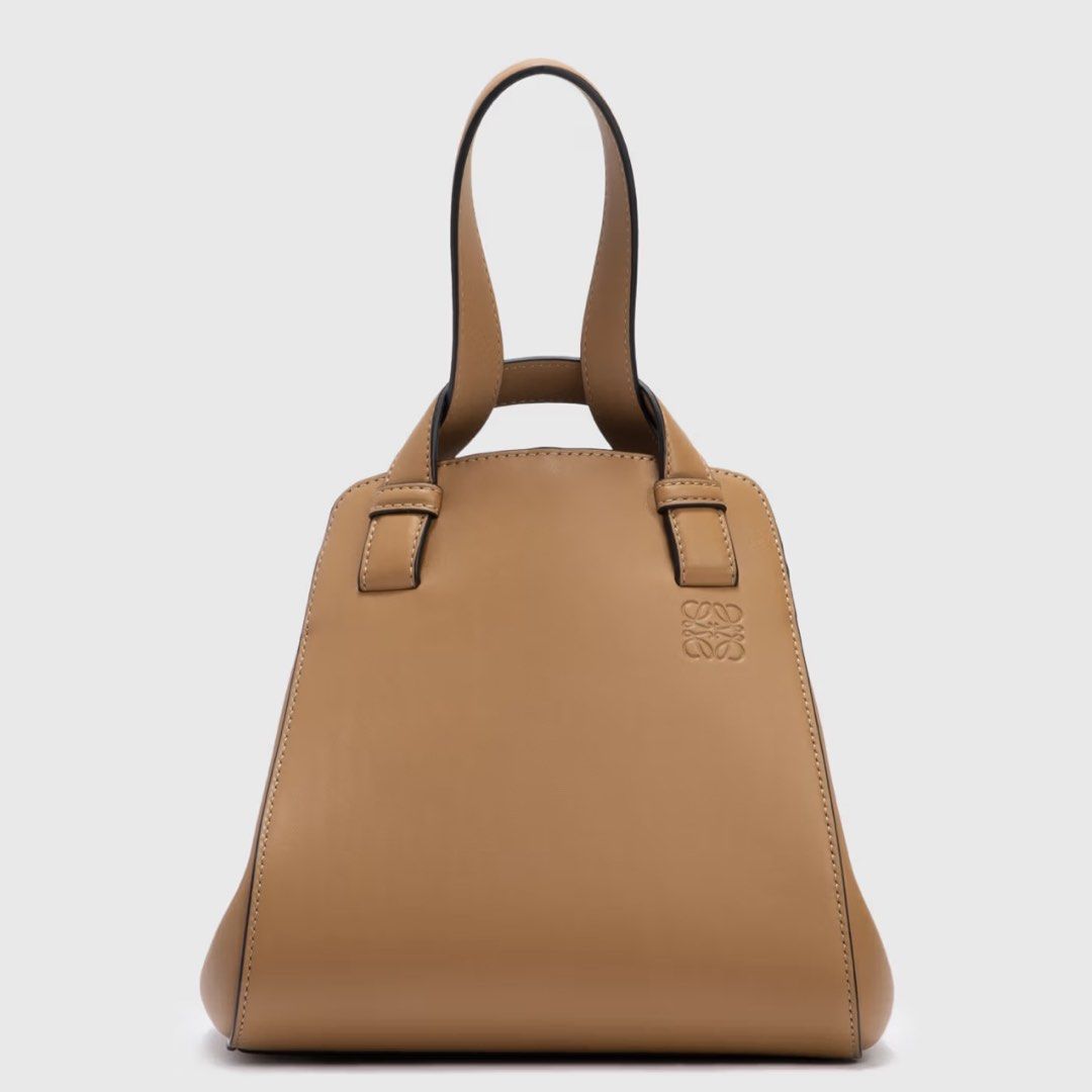 Loewe Hammock Nugget in Tan Leather (Category: Luxury Bags & Wallets) located in Makati City. Submitted by the_ambitious_peasant (Listing ID 1443947367, Image 1). Description: - Loewe Hammock Nugget in Tan Leather - Color: Tan - Material: Soft leather - Carrying options: Handheld or crossbody - Interior: Suede lined - Size: Ideal for essentials - bag and dust bag - Rank: 9/10 Note: there are very minimal signs of wear. Small white spots (not visi