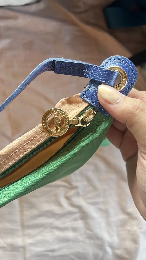 Longchamp (Category: Cross-body Bags) located in Taguig. Submitted by declutter67 (Listing ID 1443967423, Image 3). Description: - Cute Longchamp shoulder bag - Reversible design: Green on one side, Pink on the other - Blue leather strap and trim - Gold zipper detail - Great for everyday use - Plenty of space inside for essentials.