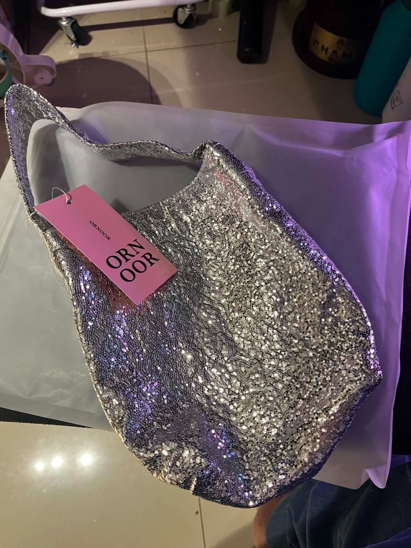 ORNOOR Cotton Silver Sequin Bucket Bag (Category: Purses & Pouches) located in Quezon City. Submitted by astargeaaa (Listing ID 1444020798, Image 3). Description: - Super cute silver sequin bucket bag - Sparkly material catches the light beautifully - Single strap for comfortable carrying - Secure snap closure inside - Ideal for night outs or adding a touch of glam to any outfit - Small and stylish accessory - ORNOOR Korean Brand.