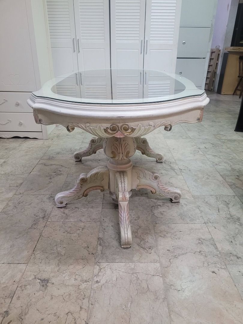 Oval Glass Top Dining Table with Ornate Base (Category: Tables & Sets) located in Quezon City. Submitted by japandemanila (Listing ID 1444039386, Image 2). Description: - Unique oval dining table with a vintage feel. - Features a beautiful glass top with decorative wood inlay underneath. - Ornate, carved wood base with a distressed white and gold finish. - Perfect for your dining room or as a stunning statement piece. JAPAN SURPLUS *6 Magdiwang s